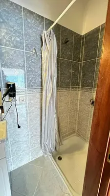 a shower with a clear shower curtain in a bathroom at Sea View Retreat in Caniço