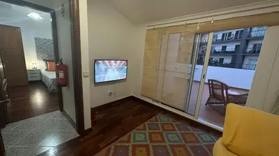 a living room with a tv and a room with a window at Sea View Retreat in Caniço
