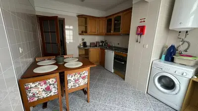 a kitchen with a table and a washing machine at Sea View Retreat in Caniço