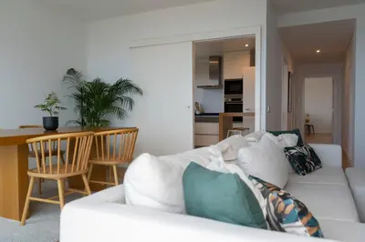 a living room with a white couch with pillows at White Apartment in Funchal