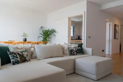 a living room with a white couch with pillows at White Apartment in Funchal