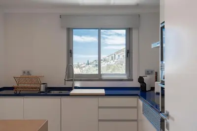 a kitchen with a sink and a window in it at White Apartment in Funchal