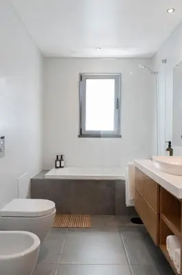 a bathroom with a tub and a toilet and a sink at White Apartment in Funchal