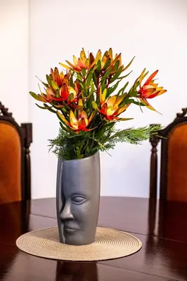 a vase with flowers in it on a table at Picturesque stay Porto da Cruz in Porto da Cruz