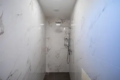 a bathroom with a shower with white marble walls at Picturesque stay Porto da Cruz in Porto da Cruz