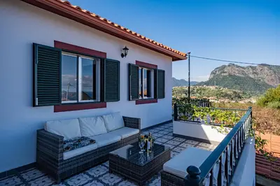 a patio with a couch and a table on a balcony at Picturesque stay Porto da Cruz in Porto da Cruz