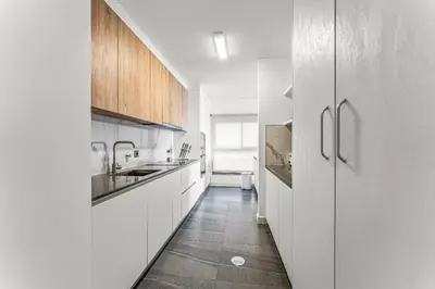 a kitchen with white cabinets and a tile floor at Sao Lucas Apartment Top Location in Funchal