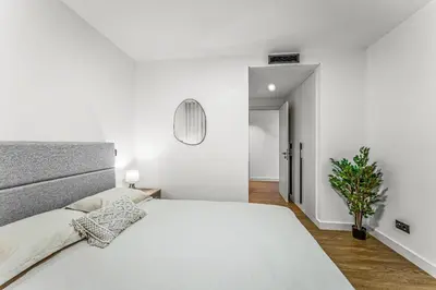 a white bedroom with a large bed and a plant at Sao Lucas Apartment Top Location in Funchal