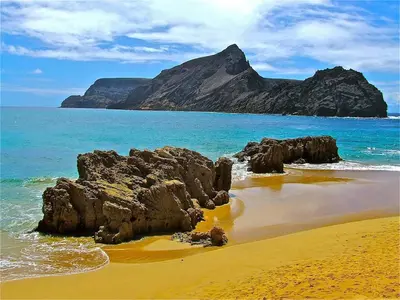 a beach with rocks and the ocean and a mountain at Golden Villa - Luxurious Beach Villa in Porto Santo