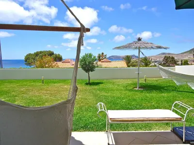a hammock in a yard with a view of the ocean at Golden Villa - Luxurious Beach Villa in Porto Santo