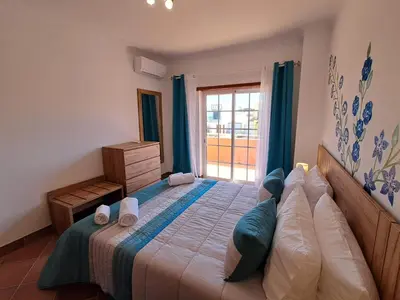 a bedroom with a large bed with a window at Villa Praia Porto de Mós in Lagos