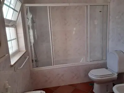 a bathroom with a shower and a toilet and a sink at Villa Praia Porto de Mós in Lagos