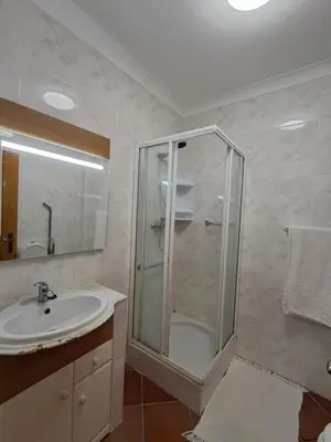 a bathroom with a shower with a glass door at Villa Praia Porto de Mós in Lagos