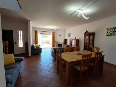 a kitchen and living room with a table and chairs at Villa Praia Porto de Mós in Lagos