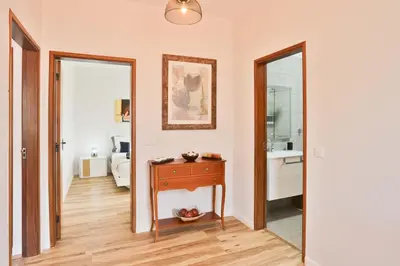 a room with a table and a mirror and a bathroom at Vila Vitalia in Machico