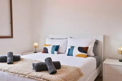 a bedroom with a large white bed with pillows at Vila Vitalia in Machico