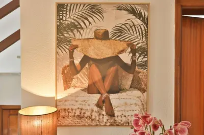 a picture of a person sitting on a bed with a hat at Vila Vitalia in Machico