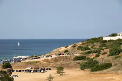 a bunch of cars parked on a hill next to the ocean at Beach View Lagos in Lagos