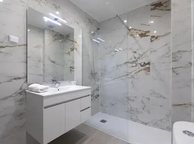 a white bathroom with a sink and a shower at Beach View Lagos in Lagos