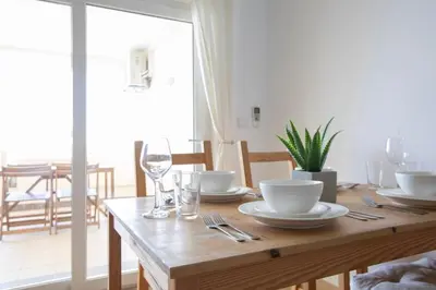 a wooden table with plates and glasses on it at Beach View Lagos in Lagos