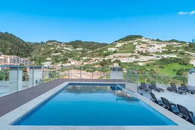 a swimming pool on top of a house with chairs at Refúgio na Quinta Girassol in Caniço