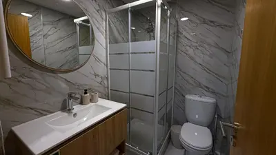 a bathroom with a toilet and a sink and a mirror at Refúgio na Quinta Girassol in Caniço