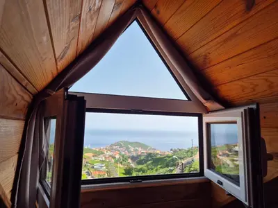 a window in a room with a view of the ocean at Quinta do Ribeiro Real in Câmara de Lobos