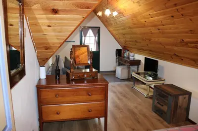 a attic room with a dresser and a wooden ceiling at Quinta do Ribeiro Real in Câmara de Lobos