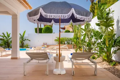 a patio with a table and chairs and an umbrella at Tropical Beach Villa by Blue Diamond 21 in Lagos