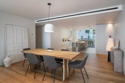 a dining room and kitchen with a wooden table and chairs at Savoy Monumentalis V by An Island Apart in Funchal