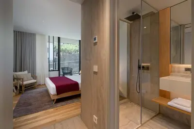 a bedroom with a bed and a bathroom with a shower at Savoy Monumentalis V by An Island Apart in Funchal