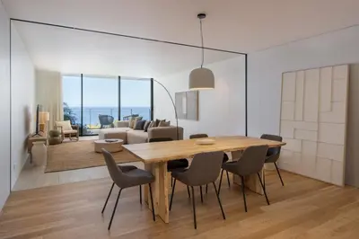 a dining room and living room with a wooden table and chairs at Savoy Monumentalis V by An Island Apart in Funchal