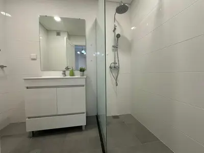 a white bathroom with a shower and a sink at Robert Apartment in Ajuda in Funchal