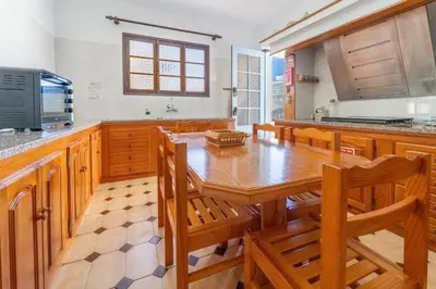 a kitchen with a table and chairs and a refrigerator at Sailor House - By Wehost in Porto Santo