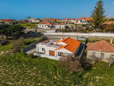 a patio with two chairs and an umbrella at Sailor House - By Wehost in Porto Santo