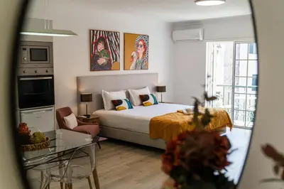 a bedroom with a bed and a living room at Funchal Heart Studio in Funchal