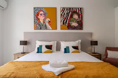 a bedroom with a bed with two pictures on the wall at Funchal Heart Studio in Funchal
