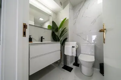 a white bathroom with a toilet and a sink at Funchal Heart Studio in Funchal