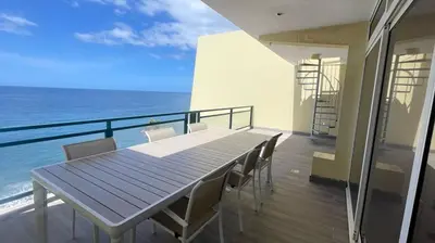 a table and chairs on a balcony with the ocean at Peaceful beachside Penthouse - 3 Bed 608 in Funchal