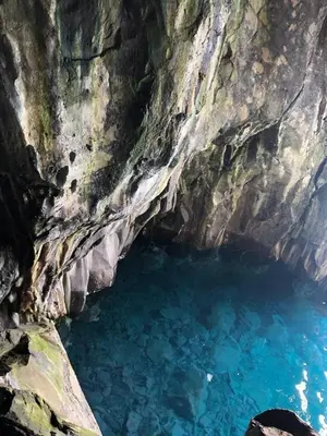 a cave filled with blue water next to a cliff at Peaceful beachside Penthouse - 3 Bed 608 in Funchal