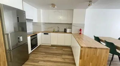 a kitchen with white cabinets and a wooden counter top at Peaceful beachside Penthouse - 3 Bed 608 in Funchal