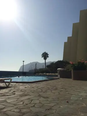 a swimming pool with a palm tree and buildings at Peaceful beachside Penthouse - 3 Bed 608 in Funchal