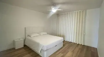 a white bedroom with a bed and a ceiling fan at Peaceful beachside Penthouse - 3 Bed 608 in Funchal
