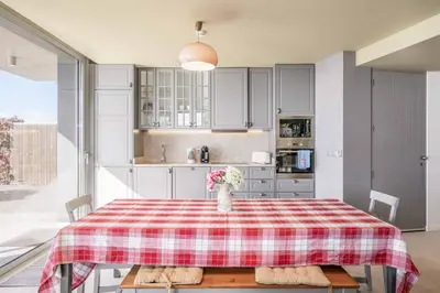 a kitchen with a table with a vase of flowers on it at Villa Fig Tree in Prazeres