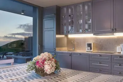 a kitchen with blue cabinets and a bouquet of flowers at Villa Fig Tree in Prazeres