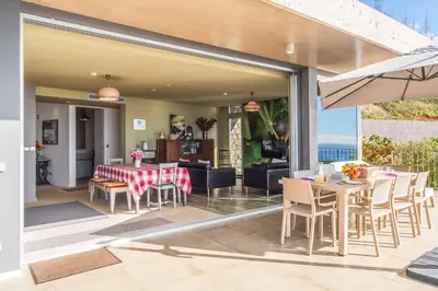 a dining area with a table and chairs and an umbrella at Villa Fig Tree in Prazeres