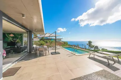 a house with a swimming pool and a view of the ocean at Villa Fig Tree in Prazeres