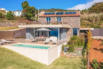 a home with a swimming pool and a house at Villa Fig Tree in Prazeres