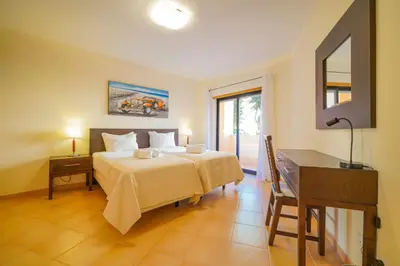 a bedroom with two beds and a couch and a window at Estrela Apartment by Moje Holiday in Luz