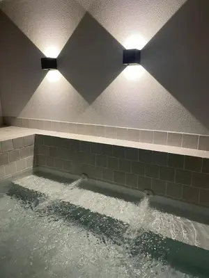 two lights above a bath tub with water at Calheta Suites - Vinha & Jardim - Adults-only suites met hottub & zeezicht in Calheta